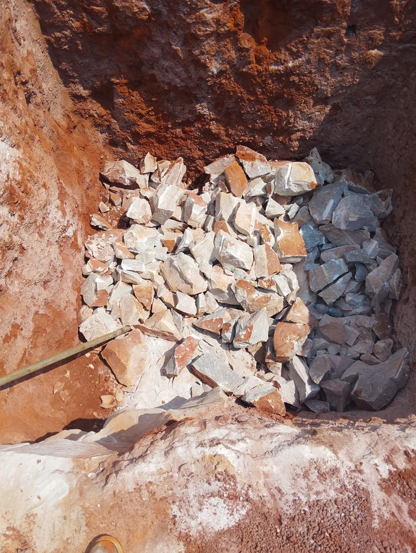The same pit with the rock broken into liftable pieces
