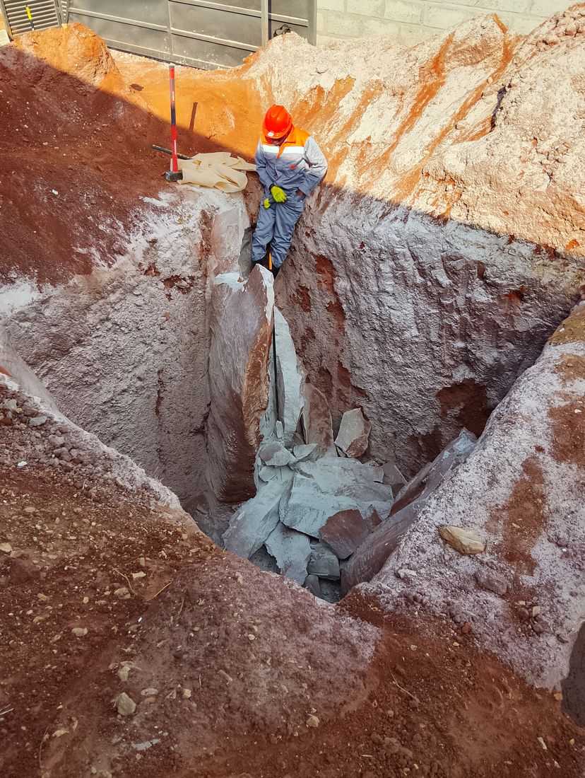 Crew splitting the rock clean deep in the pit, no blasting